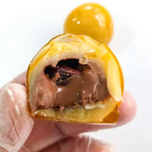 Bala caramelizada com recheio de Nutella, cortada ao meio